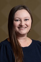 headshot of carrie jenkins, long brown hair, blue shirt